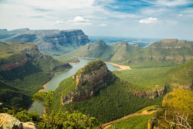 Canyon verdoyant avec rivière sinueuse et formations rocheuses dans un paysage naturel d’Afrique du Sud
