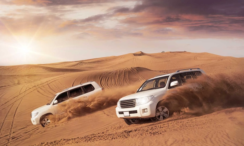 Véhicules 4x4 traversant les dunes du désert d’Abu Dhabi lors d’un safari au coucher du soleil