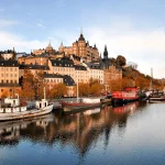 Vue du front de mer à Stockholm avec bateaux et bâtiments historiques, proposée par 2s africa travel, agence de voyages à Rabat